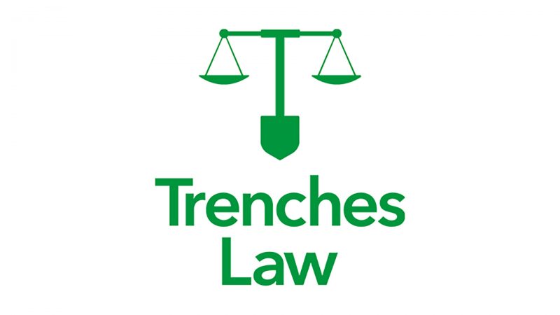 Green logo of Trenches Law firm depicting a pair of scales