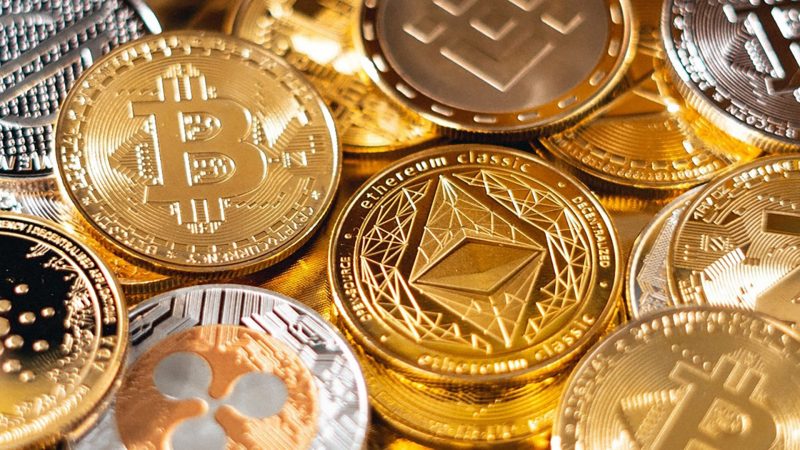 A pile of gold coins representing different cryptocurrencies